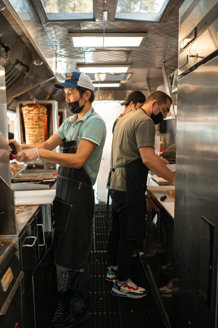 services-03 Chefs working in a food truck preparing delicious street food for customers.